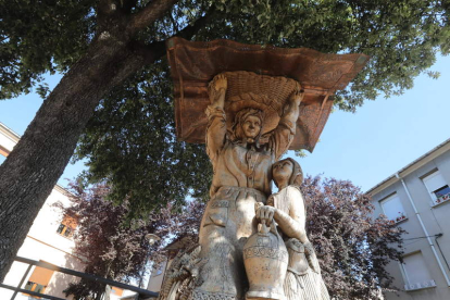 Una campesiona y una niña en un árbol tallado en Columbrianos, obra de Rixo. ANA F. BARREDO