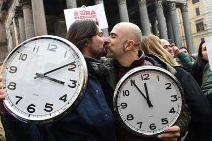 Una pareja con dos grandes relojes en la manifestación de Roma.