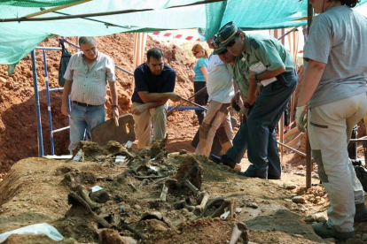 Dos agentes supervisan la exhumación de los restos mortales encontrados en la fosa de Joarilla de las Matas, una imagen poco frecuente en las catas.