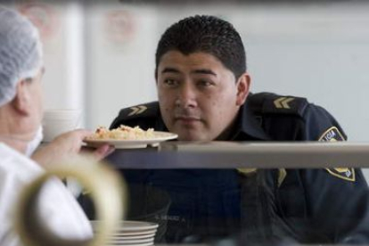 Un policía recibe sus alimentos en un destacamento.