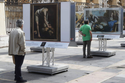Imágenes de los primeros visitantes de la exposición ‘El Museo del Prado en las calles’, instalada en la plaza de Regla, en la fachada sur de la Catedra. RAMIRO