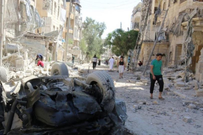Varias personas inspeccionan los daños causados por un bombardeo nocturno contra el barrio rebelde de Seif al-Dawla, en Alepo, el 30 de septiembre.