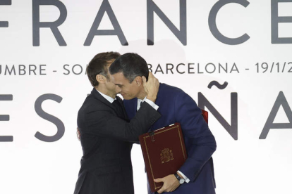 El presidente francés, Emmanuel Macron, abraza a Pedro Sánchez durante la ceremonia de firma de acuerdos. ALBERTO ESTÉVEZ