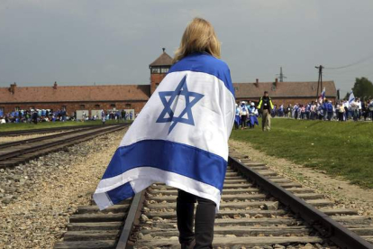 Una mujer camina junto a las vías del tren que lleva a Auschwitz durante la tradicional «Marcha de los vivos».