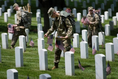 Soldados de EEUU colocan banderas en las tumbas del cementerio de Arlington (Virginia), el 26 de mayo.