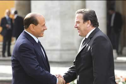 Berlusconi saluda en el momento de la llegada al representante alemán.