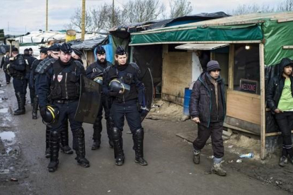 Agentes de seguridad patrullan el campamento conocido como 'La jungla' en Calais que fue desmantelado.