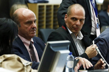 El ministro español de Economía y Competitividad, Luis de Guindos (i), y el ministro de Finanzas griego, Yanis Varufakis (d), asisten a una reunión de los ministros de Finanzas del Eurogrupo en la sede del Consejo Europeo de Bruselas.