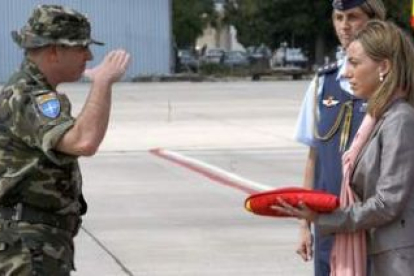 Chacón recibe la bandera entregada por el responsable del contingente español.