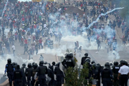 Opositores y policía se enfrentan cerca del Estadio Nacional de Tegucigalpa antes de la toma de posesión del presidente de Honduras, Juan Orlando Hernández.