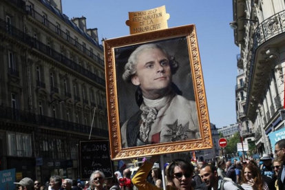 Los manifestantes contrarios a Macron muestran un retrato del rey Luis XIV con la cara del actual presidente.