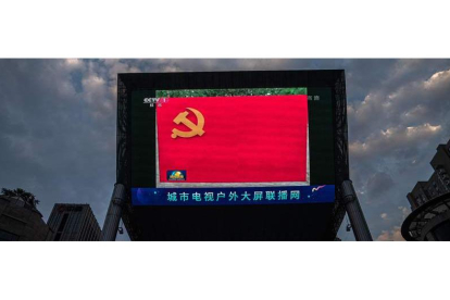 Una pantalla de grandes dimensiones muestra la bandera del Partido Comunista chino en las noticias de la tarde, ayer en Pekín. ROMAN PILIPEY