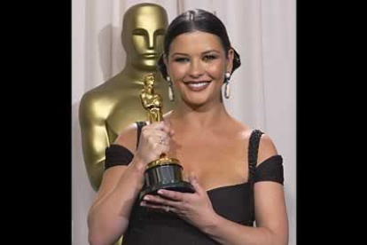 Catherine Zeta-Jones posa emocionada con su Oscar que la academia le otorgó como mejor actriz de reparto en Chicago.