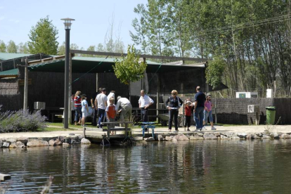 Un grupo de visitantes, en el lago donde se practica pesca sin muerte en el Aula del Río situada en Vegas del Condado. JAVIER