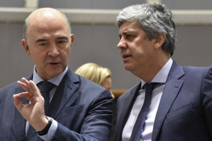 El comisario europeo de Economía, Pierre Moscovici, conversa con el ministro portugés de Finanzas, Mario Centeno, este martes en Bruselas.