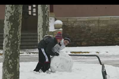 Los más pequeños suelen ser los que más partido sacan a las nevadas. En la imagen, dos niñas tratan de hacer un muñeco de nieve