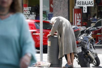 Un mendigo revisa una papelera en una de las calles del centro de la ciudad. BRUNO MORENO