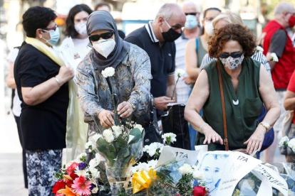 Imagen de ciudadanos poniendo flores en el aniversario del atentado. QUIQUE GARCÍA