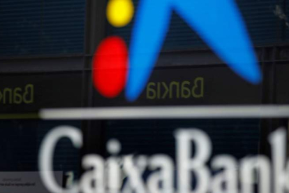 Vista de una oficina de CaixaBank donde se refleja el logo de Bankia. TONI ALBIR