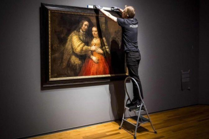 Unos operarios del Rijksmuseum cuelgan La novia judía, de Rembrandt, para la exposición que el museo dedica al artista en el 350 aniversario de su muerte.
