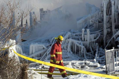 Un bombero camina entre los restos de la residencia incendiada en L'Isle-Verte (Canadá), este jueves.