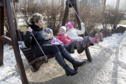 Una mujer y tres niños disfrutan del día de sol, sin bombas, en Donetsk.