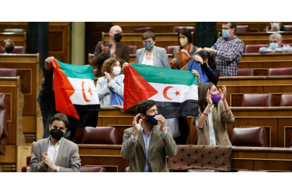 Diputados de Unidas Podemos ondean banderas saharauis durante el pleno en el Congreso, ayer. MARISCAL