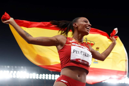 Ana Peleteiro celebra con la bandera de España su medalla de bronce lograda en el triple salto. BRUNA