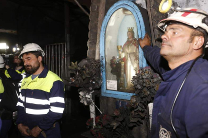 La imagen de ‘la santina’, con sus flores tiznadas, ilumina la entrada a cada grupo minero. Debajo, la foto del compañero fallecido. MARCIANO