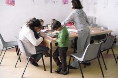 Una monitora atiende a un grupo de niños en la ludoteca