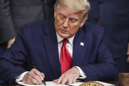 Donald Trump firma una resolución. OLIVER CONTRERAS
