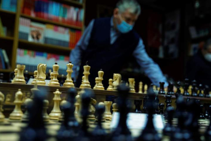 Un empleado coloca las figuras en el tablero en la tienda especializada la casa del ajedrez en Madrid. EMILIO NARANJO