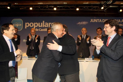 El presidente del PP de Castilla y León, Juan Vicente Herrera, y el vicesecretario general de Política Autonómica y Local, Javier Arenas, se abrazan ante la mirada de, ex presidente del PP regional Juan José Lucas, el secretario general del Partido en Cas