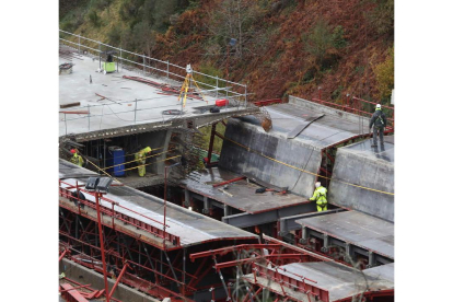 Varios trabajadores, ayer, en la obra para asentar en la montaña el viaducto dirección Madrid; a la derecha, otra vista general. L. DE LA MATA