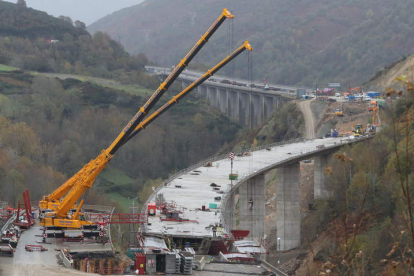 Varios trabajadores, ayer, en la obra para asentar en la montaña el viaducto dirección Madrid; a la derecha, otra vista general. L. DE LA MATA