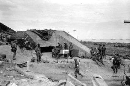 Soldados ante un bunker en la playa de Omaha.