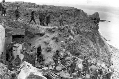 Soldados ante un bunker destruido en Pointe du Hoc.