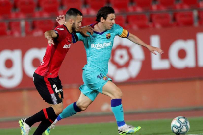 El astro del Barça Lionel Messi controla el balón ante el defensa del Mallorca Joan Sastre. JUANJO MARTÍN
