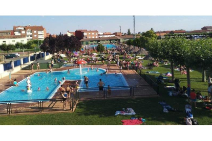 Vista general de las piscinas municipales de Santa María del Páramo con la infantil en primer plano y la de adultos al fondo. DL