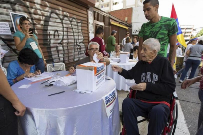 Un grupo de personas participa en la votación de la oposición en Caracas.