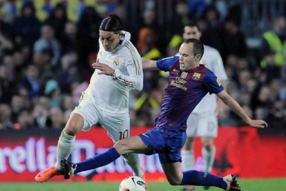 Andres Iniesta lucha un balón con Ozil durante la primera parte del partido. Foto: AP / ALVARO BARRIENTOS