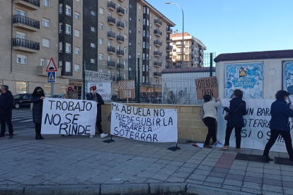 Personas con pancartas de protesta esperan al presidente Pedro Sánchez esta mañana. DL