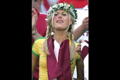 Algunos, sin embargo, tienen su corazón dividido, como esta aficionada letona, que bajo la bandera de su selección, lucía una camiseta de Brasil. Eso sí, su corona de margaritas se marece un diez en glamur.