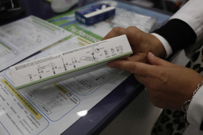 Una farmacéutica muestra las instrucciones para realizar un test de antígenos. FERNANDO OTERO PERANDONES