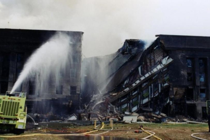Los bomberos tratan de extinguir el fuego originado despues de que el vuelo 77 de American Airlines impactase contra las instalaciones del Pentagono.