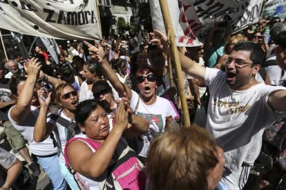 Un grupo de personas se manifiestan en el centro de Buenos Aires, en protesta por los despidos masivos de trabajadores estatales, este miércoles.
