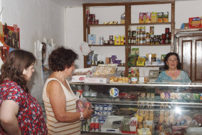 Sagrario de la Mota atiende a unas clientas en su tienda de ultramarinos de Grajal de Campos. ACACIO