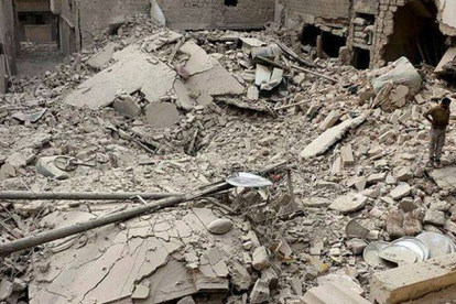 Un hombre, junto a varias casas destruidas en Alepo tras un ataque del Ejército sirio.
