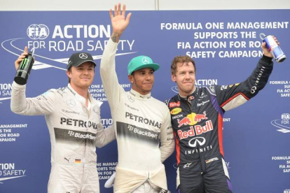 El piloto de Mercedes Lewis Hamilton, el piloto de Red Bull Sebastian Vettel y el de Mercedes Nico Rosberg de Alemania después de que Hamilton haya conseguido la 'pole' en el Gran Premio de Malasia.