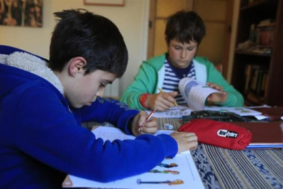 Pau y Unai, alumnos de quinto de primaria, hacen deberes en casa de uno de ellos.